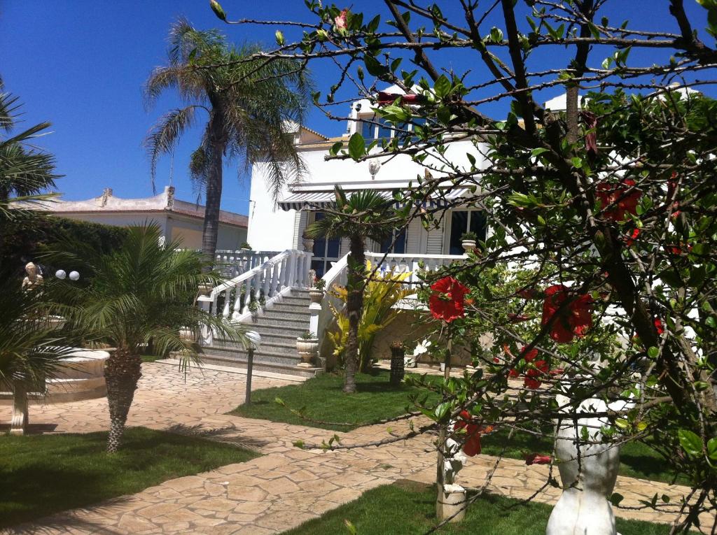 una casa blanca con escaleras y palmeras delante en Villa Sissi, en Cava dʼAliga