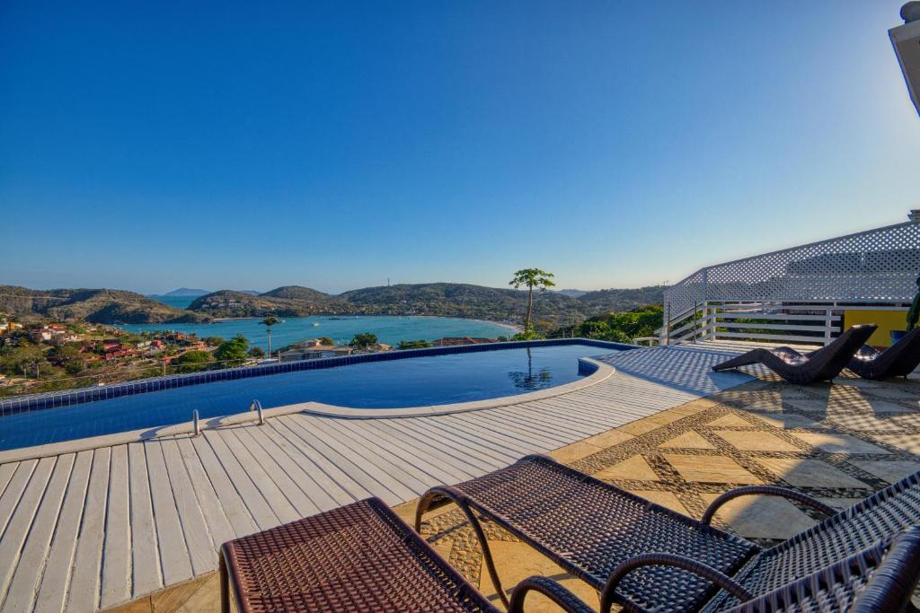 Búzios - Villa exceptionnelle في بوزيوس: فناء مع كراسي وحمام سباحة