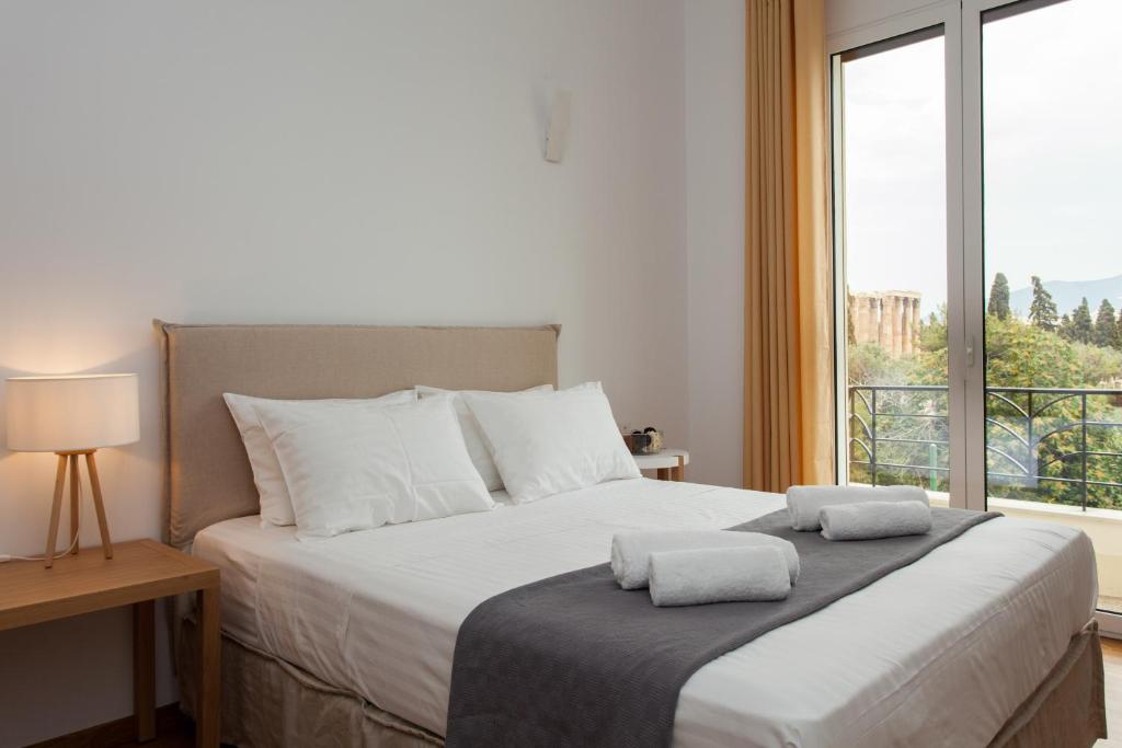 a bedroom with a large bed with two towels on it at Nakos Homes Luxury Apartment-Acropolis Area in Athens