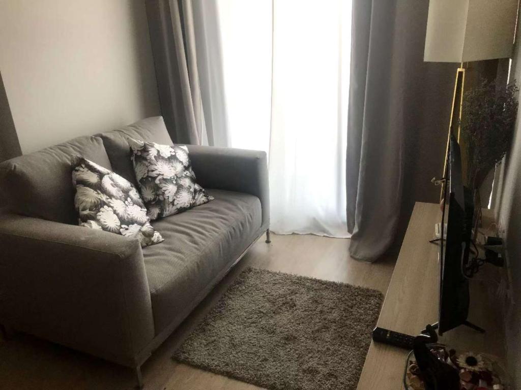 un salon avec un canapé et une fenêtre dans l'établissement Home hugs, à Bangna