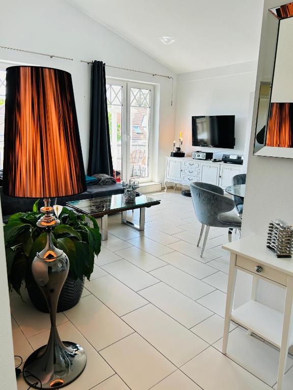 a living room with a lamp on a tiled floor at Wohnung Hafenblick in Zingst