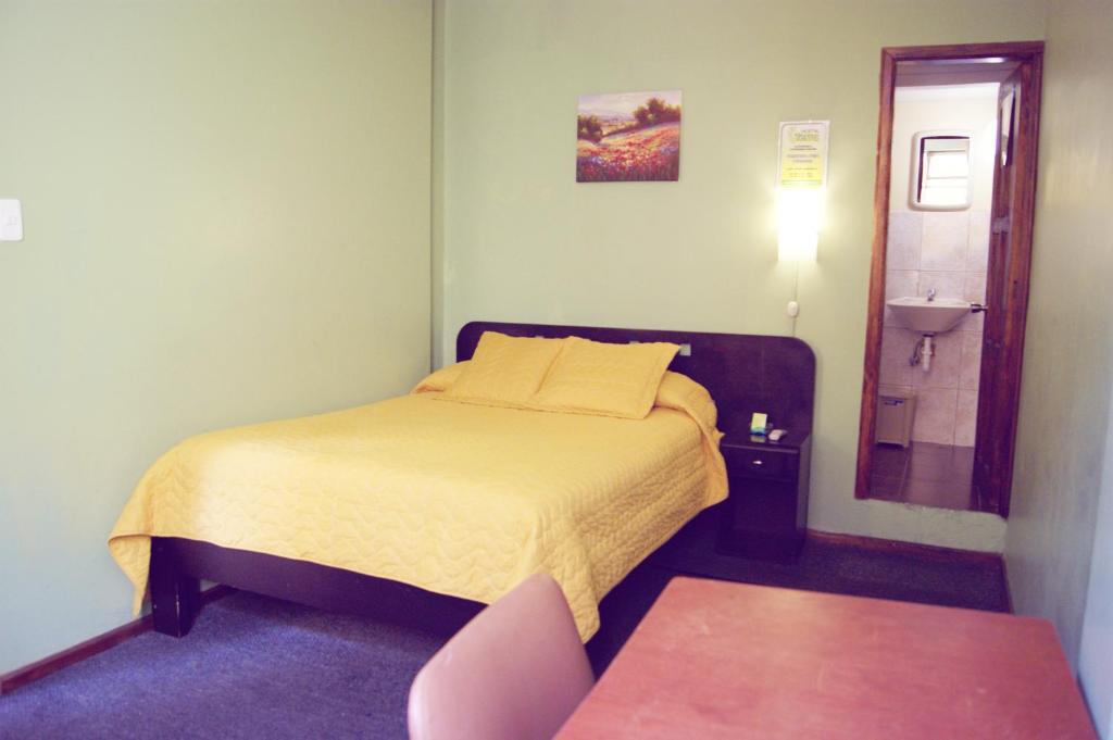 Dormitorio pequeño con cama y lavamanos en Hostal Terra 4 - EL LABRADOR, en Quito
