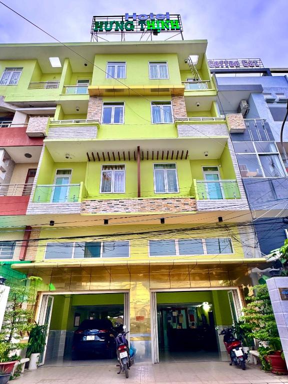 a yellow building with cars parked in front of it at Hưng Thịnh 1 in Can Tho