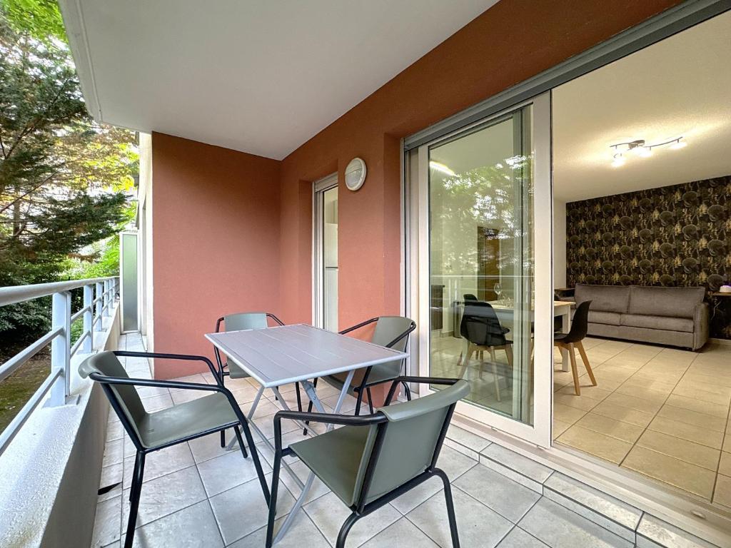 Un patio con una mesa y sillas en un balcón. en Cosy nid, terrasse & 2 parkings, en Antibes