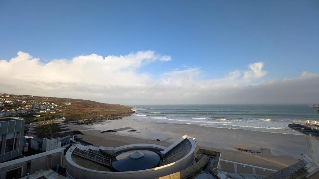 a view of a beach and the ocean from a building at Tate Five Penthouse apartment with panoramic views of St Ives in St Ives