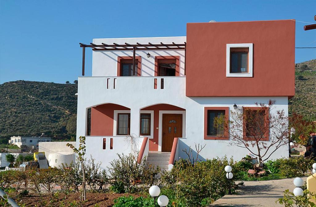 una casa bianca e rossa con una collina sullo sfondo di Eden Villa ad Alinda