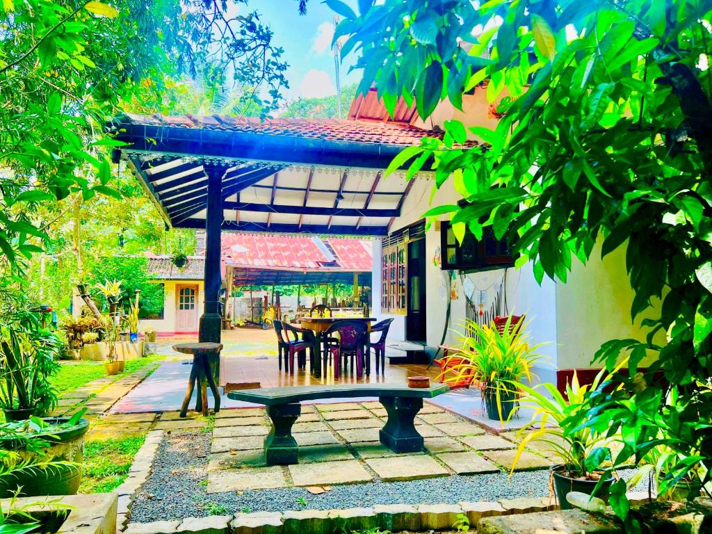 a bench in a garden with a table and chairs at DK Paddy Field Villa in Unawatuna in Unawatuna