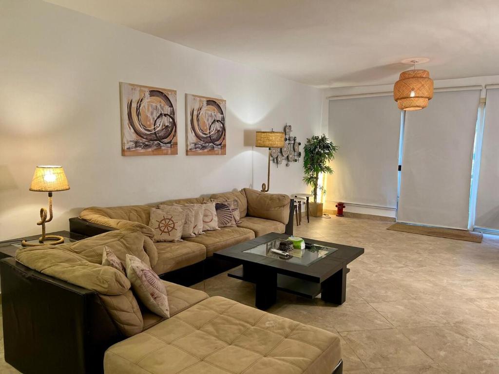 3BR Duplex with Private Rooftop in Ein Bay في العين السخنة: غرفة معيشة مع أريكة وطاولة قهوة