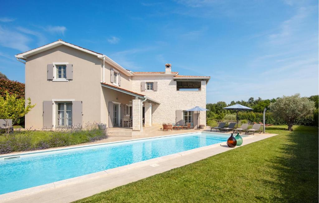 a villa with a swimming pool in front of a house at Villa Corinne in Štuti