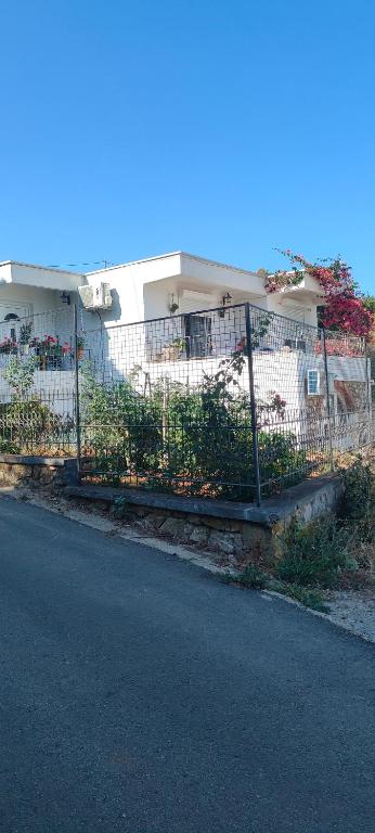a fence in front of a house with flowers at Apartman Asja in Utjeha