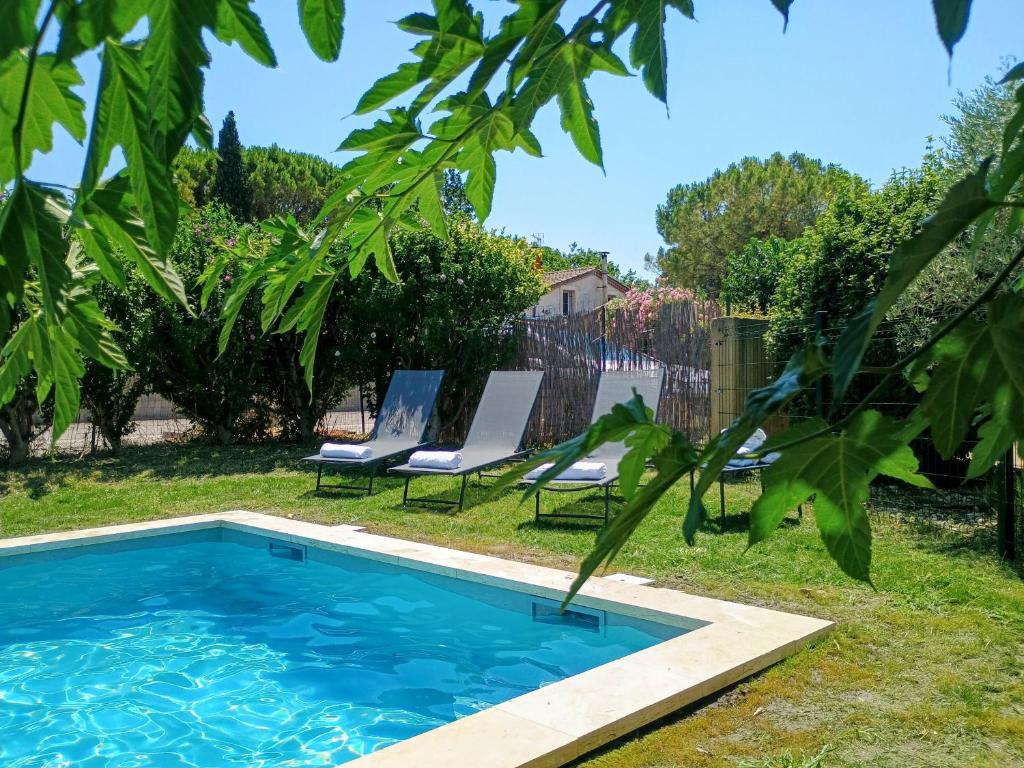 - une piscine dans une cour avec 2 chaises longues dans l'établissement Villa Beau Soleil Piscine Jardin Parking, à LʼIsle-sur-la-Sorgue