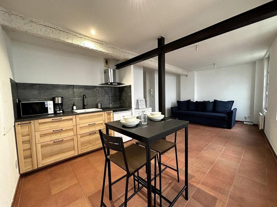une cuisine avec une table et des chaises dans une pièce dans l'établissement Studio au calme sur Avignon, à Avignon