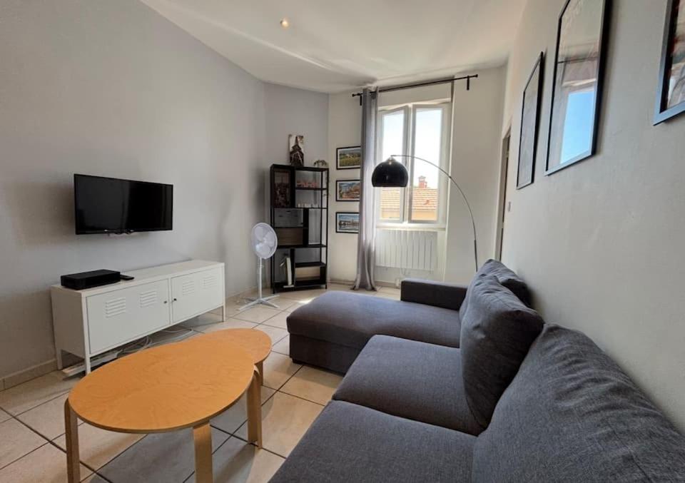 un salon avec un canapé et une table dans l'établissement Appartement pour 2 à 4 personnes proches du centre, à Avignon