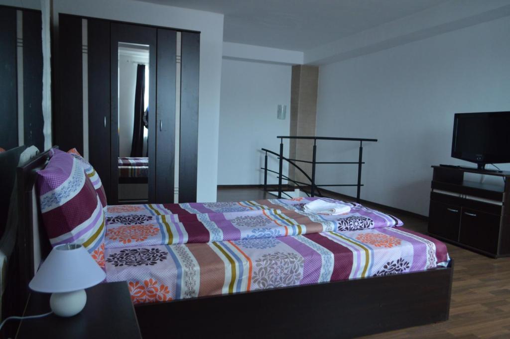 1 dormitorio con 1 cama con un edredón colorido en Csikos Apartment en Cluj-Napoca