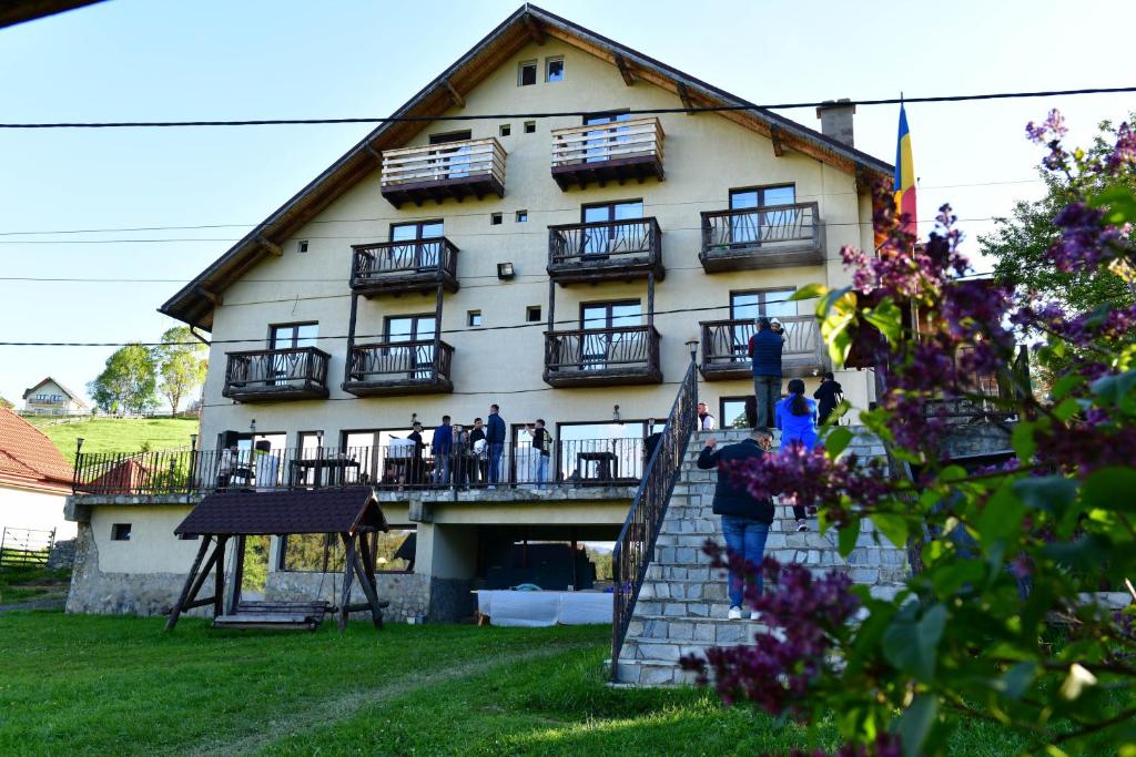 a large building with people standing on the balcony at Pensiunea Ursul Carcotas in Fundata