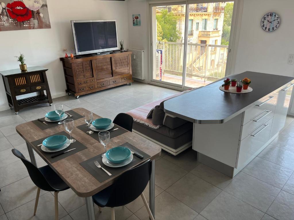 une cuisine et un salon avec une table et des chaises dans l'établissement Très beau 3 pièces spacieux lumineux et climatisé, à Nice