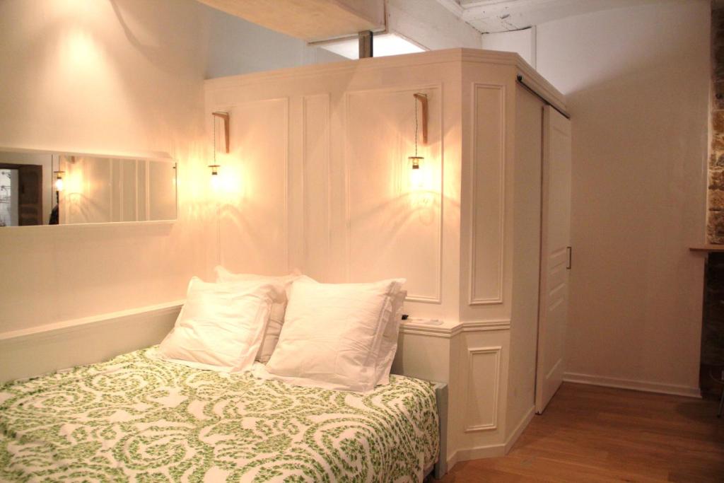 sypialnia z łóżkiem z 2 poduszkami i szafką w obiekcie La Suite Presqu'Ile w mieście Lyon