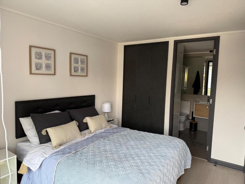 um quarto com uma cama com um edredom azul em Acogedor departamento en Ñuñoa em Santiago