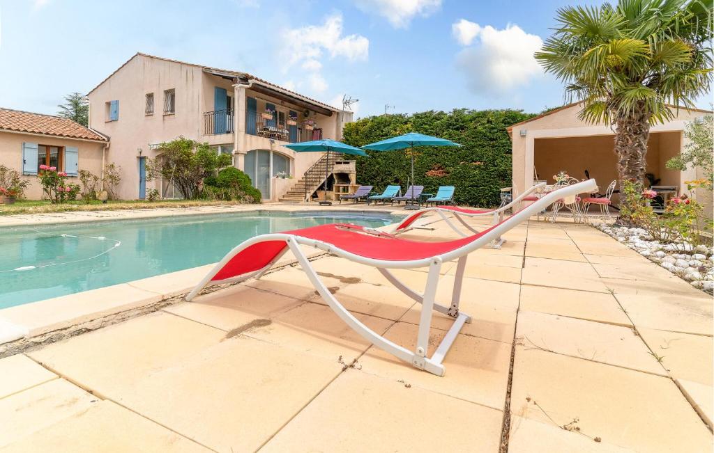 una silla roja y blanca junto a la piscina en Beautiful Home In Lauris With Wifi, en Lauris