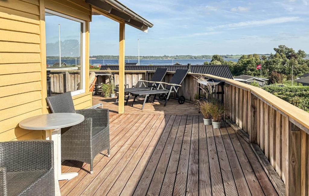 a wooden deck with chairs and a table on a house at 3 Bedroom Lovely Home In Aabenraa in Aabenraa