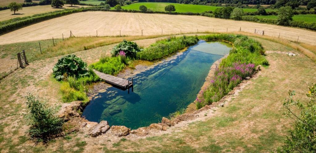 an aerial view of a pool of water in a field at Mattie's Loft in Bletchingley