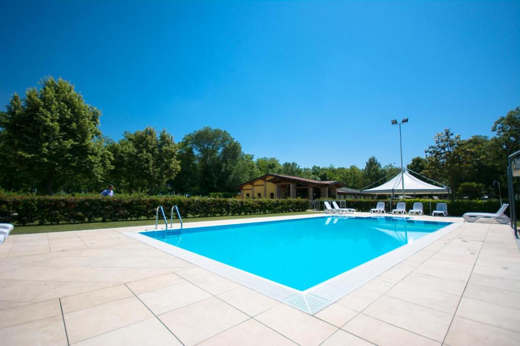 a large swimming pool with chairs and a tent at Agriturismo Al Buttasella in Lavariano