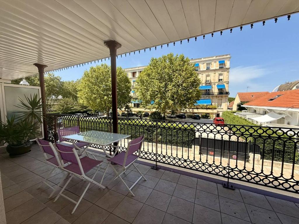 un patio avec une table et des chaises et une clôture dans l'établissement Arcachon Centre : T2 tout équipé à 150m de la plage avec loggia et parking sécurisé - FR-1-433-5, à Arcachon