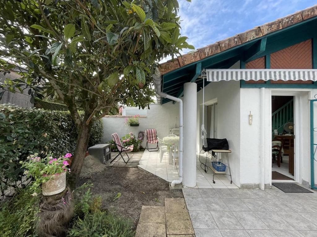 Cette maison dispose d'une terrasse couverte avec des chaises et une table. dans l'établissement Charmant T2 mezzanine pour 4 pers. avec jardinet, proche du lac à Soustons - FR-1-379-72, à Soustons