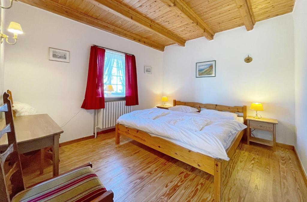 a bedroom with a bed and a desk and a window at Haus-Wolfram-App-Wilhelmine in Morsum