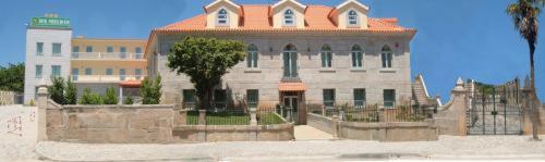 a large building with a tree in front of it at Hotel Portas Do Dao in Penalva do Castelo