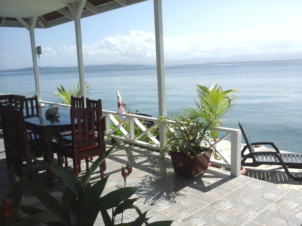 eine Veranda mit einem Tisch, Stühlen und Meerblick in der Unterkunft Paraiso Escondido in Bocas del Toro