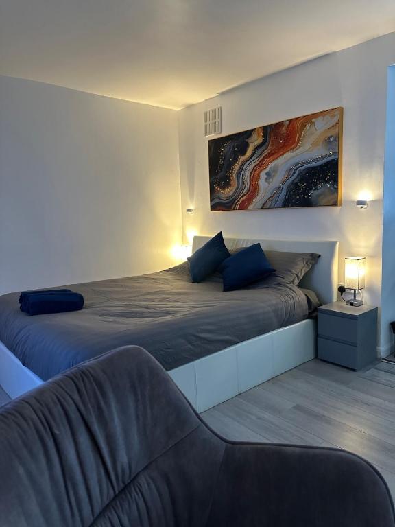 a bedroom with two beds and a couch at Watford Junction, King Size Bed in Watford