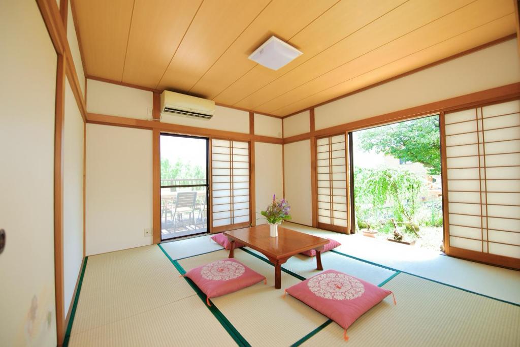 a room with a table and two pink chairs at 海の小石 in Ito