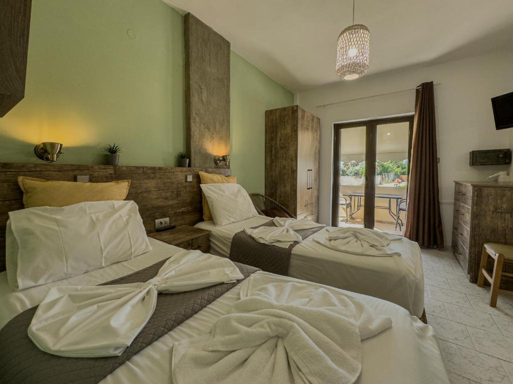 a hotel room with two beds and a balcony at Kydonia apartments in Plataniás