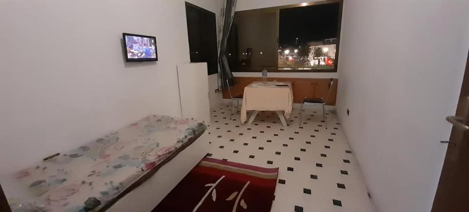 a room with a bed and a table and a window at Bab bhar sousse in Sousse