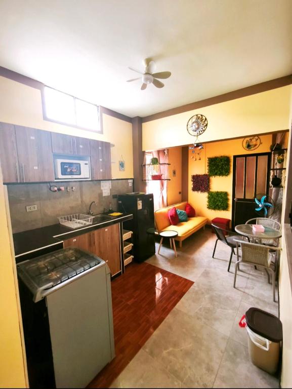a kitchen and living room with a couch and a table at Departamento Moderno y Acogedor con aire acondicionado in Tumbes