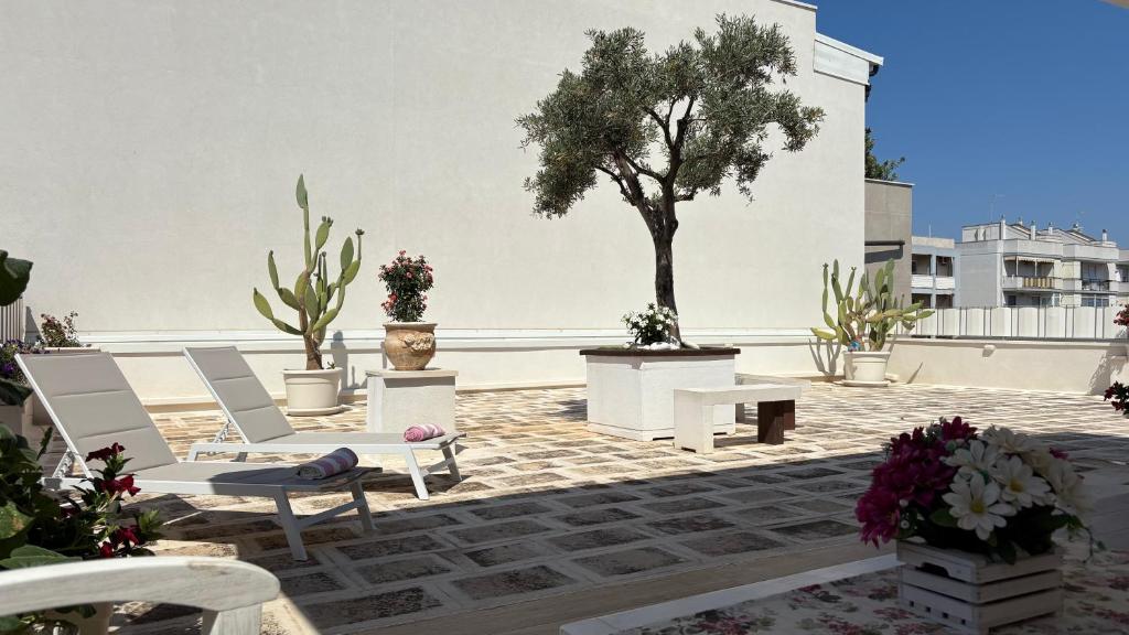 een terras met twee stoelen en een boom op een gebouw bij Pietra di Luna relaxing private terrace in Polignano a Mare