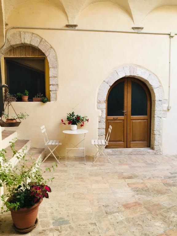 a building with a door and a table and chairs at Appartamento La Corte di Trevi in Trevi