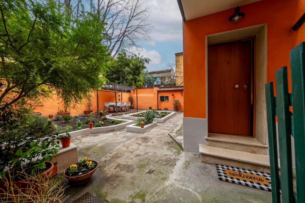 an orange building with a door in a courtyard at City centre - Beautiful cottage with garden in Bologna