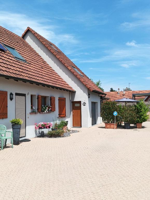 une maison blanche avec un toit rouge dans l'établissement Gîte au Cœur des champs chez Sandrine et Manu, à Hilsenheim