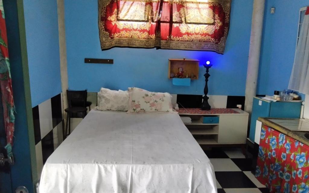 a blue room with a bed and a desk at Estúdio Bambuzal no Centro in Alto Paraíso de Goiás