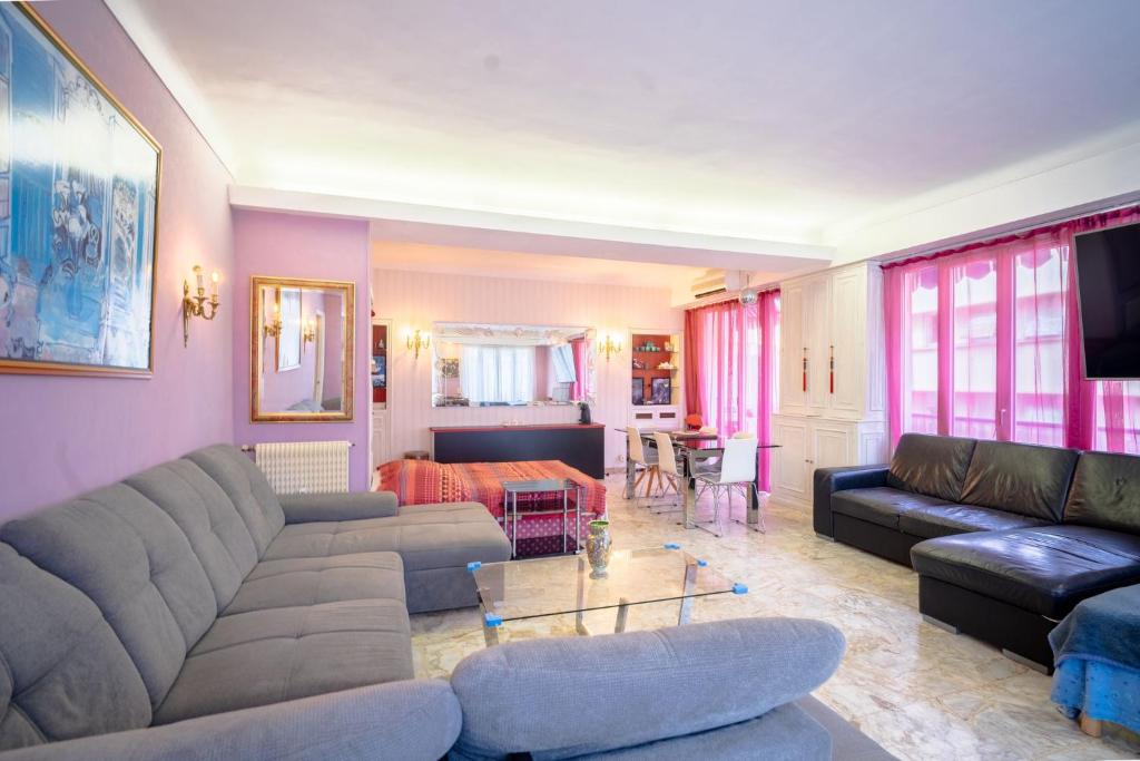 un salon avec un canapé et une table dans l'établissement Big apart 140m2 5min walk to beach sea &Promenade 3 double rooms,big living room 42m2, 3 showers,9 beds, free parking, à Nice
