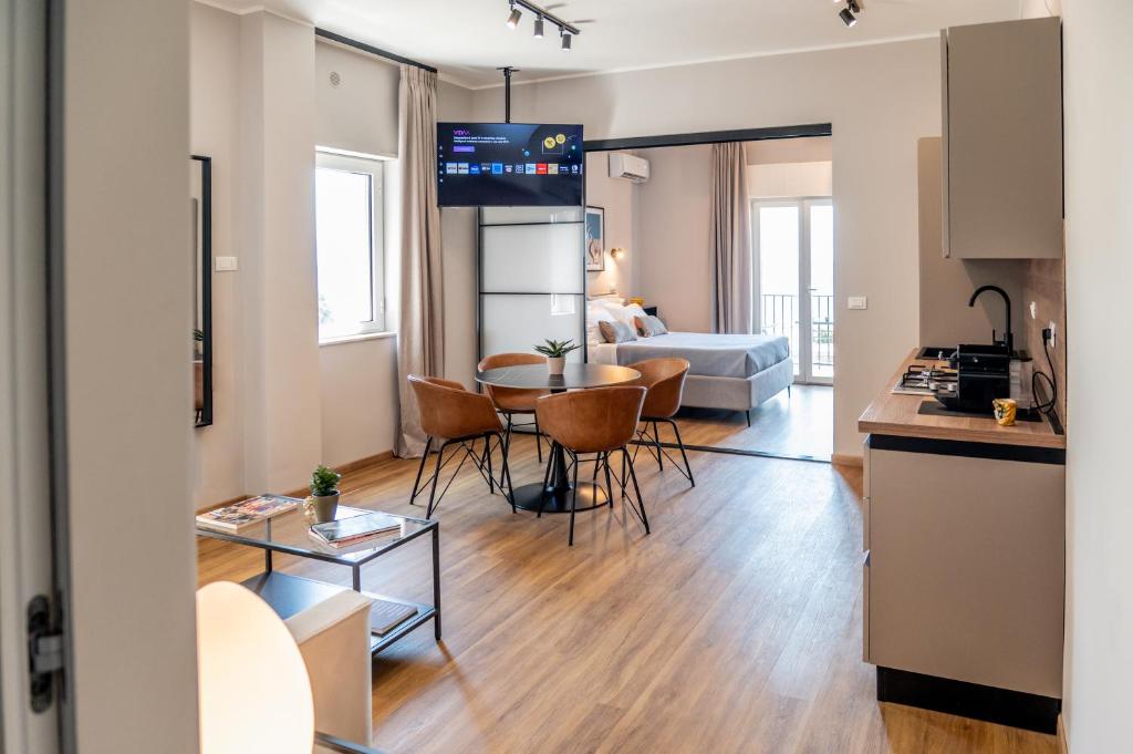 a kitchen and living room with a table and chairs at Verdemare Home in Milazzo