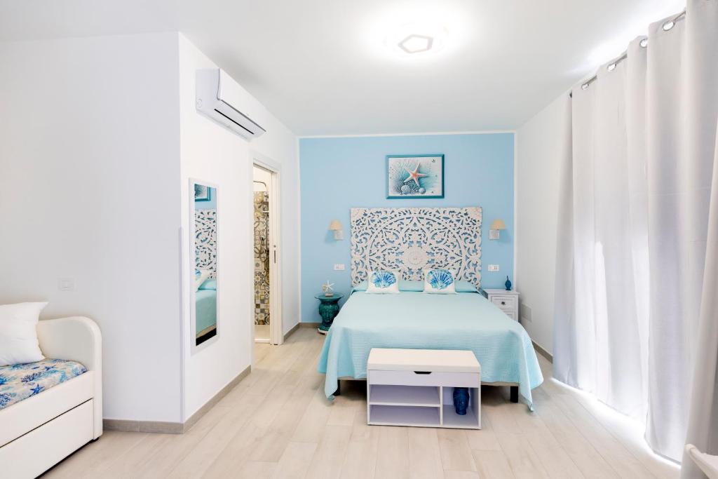 ein blaues Schlafzimmer mit einem Bett und einem Stuhl in der Unterkunft B&B Elysia in Lipari
