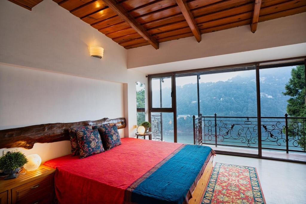 a bedroom with a large bed and a large window at Lake View 2BHK close to Mall Road l Bay Breeze in Nainital
