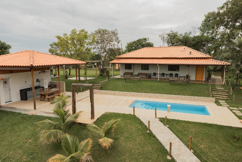 una villa con piscina y una casa en Sítio Jaboticatubas, en Jaboticatubas