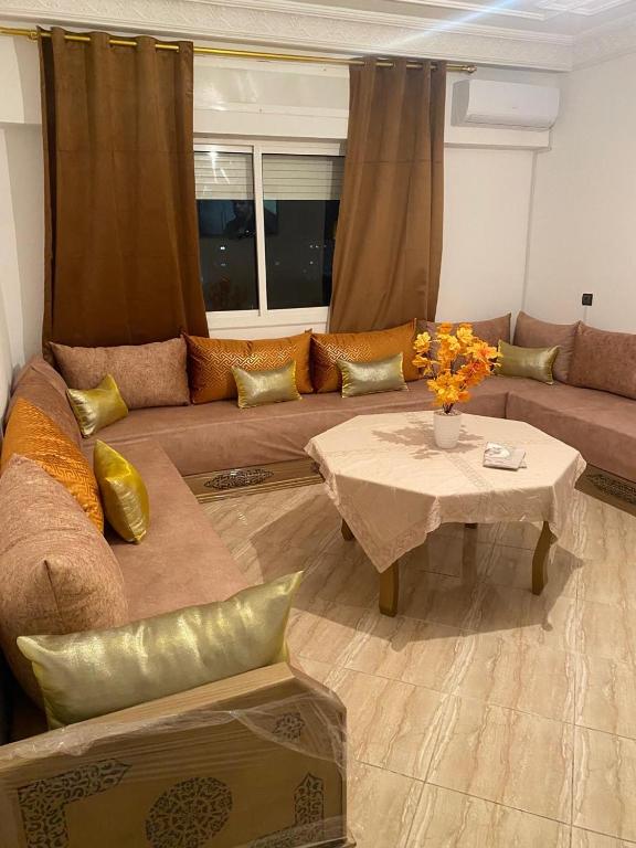 a living room with a couch and a table at Appartement Yasmine à Martil in Martil