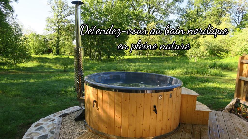 un jacuzzi en forme de tonneau dans un jardin avec les mots « samedi était un matin d'automne à dans l'établissement Sérénité Verte à La Tuilerie Accommodation, à La Bazeuge