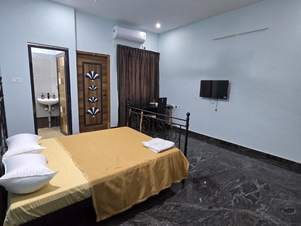 a bedroom with a bed and a sink and a television at Perumal home stay in Tiruvannāmalai