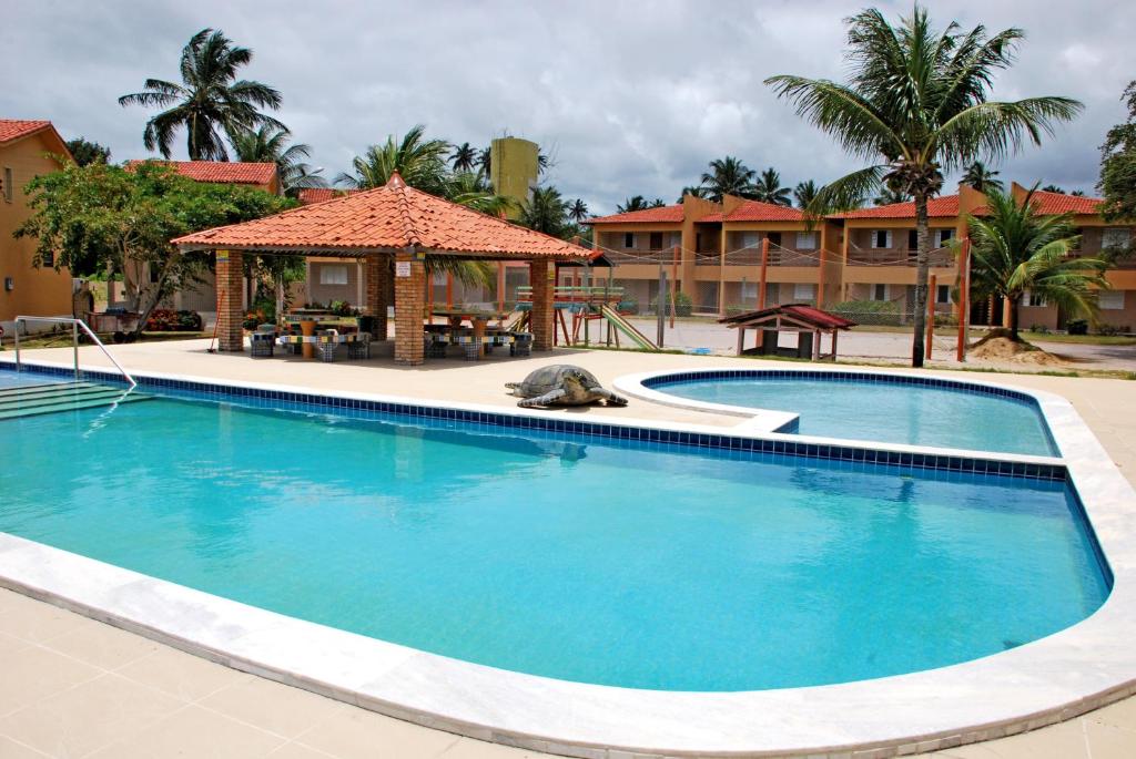 a pool at a resort with a gazebo at Privê Areias Douradas in Peroba